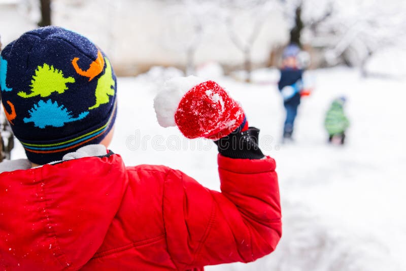 Little Children Playing with Snowballs Outdoor in the Park Stock Photo