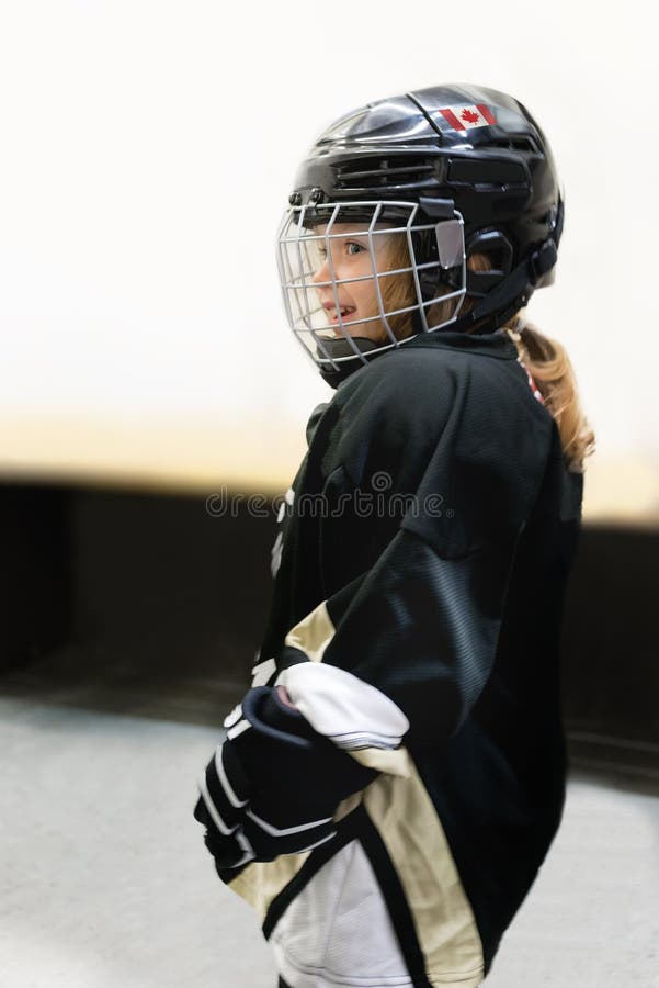 Little cute blonde Canadian 3-years old girl plays hockey in full hockey equipment stock photo Little cute blonde Canadian 3-years old girl plays hockey in full hockey equipment stock photo