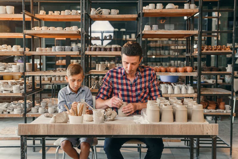 Little cute boy with his father making ceramic pots in the pottery. royalty free stock photos Little cute boy with his father making ceramic pots in the pottery. royalty free stock photos