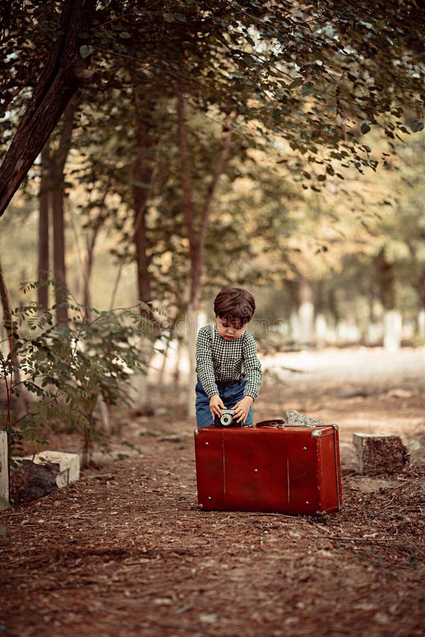Little Cute Boy in Vintage Clothes Sets Retro Camera on Vintage