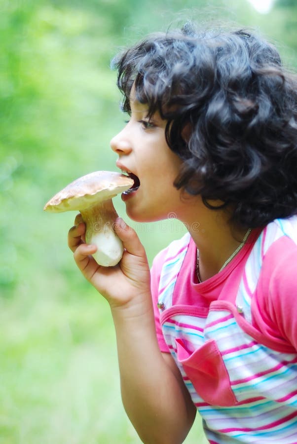 A little cute girl is eating mushroom