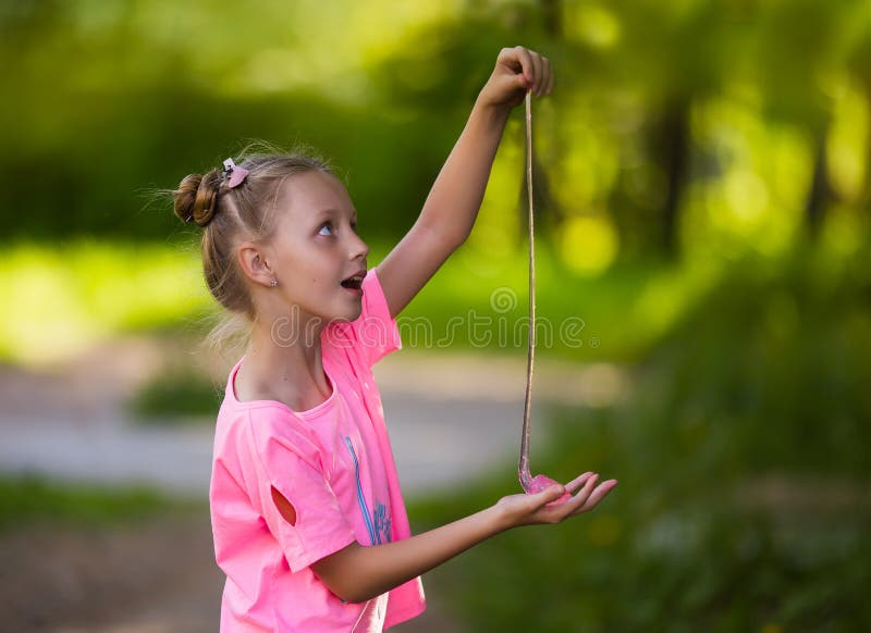 Little cute girl plays in the popular toy anti-stress for hands, chewing gum for hands, slime. Games for children and adults stock photography Little cute girl plays in the popular toy anti-stress for hands, chewing gum for hands, slime. Games for children and adults stock photography