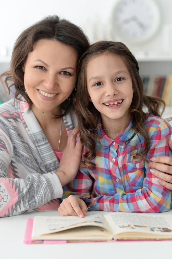 Little cute girl reading book with mother