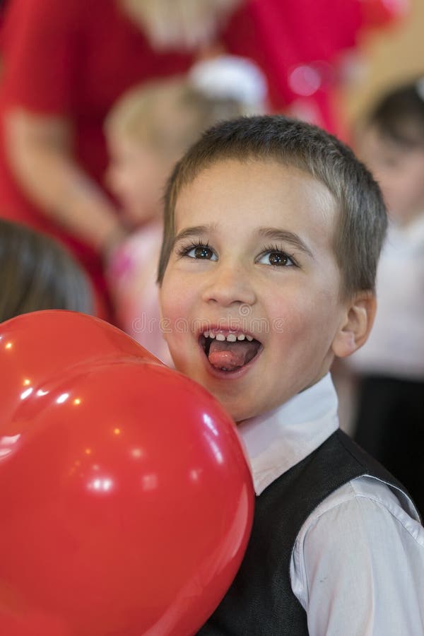Little funny boy with red balloon. portrait of a funny kid holding a big red balloon against an abstract background royalty free stock photo Little funny boy with red balloon. portrait of a funny kid holding a big red balloon against an abstract background royalty free stock photo
