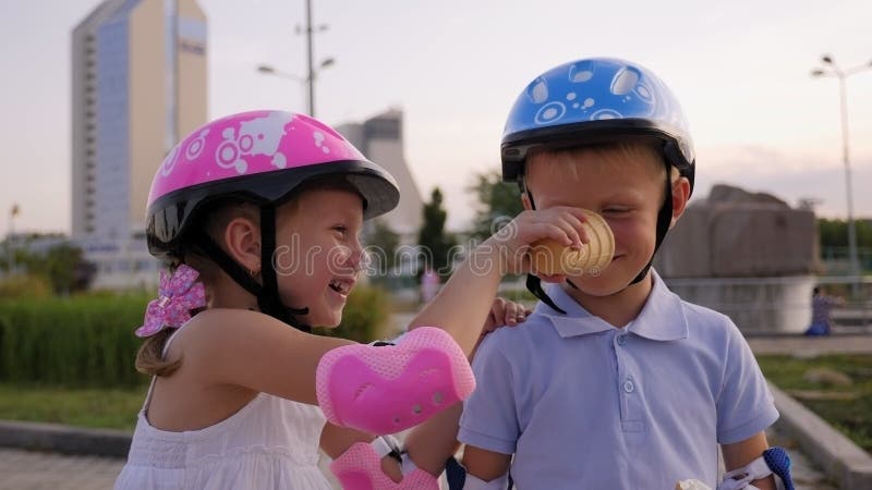 Little funny children have fun in the Park, they smear each other with ice cream