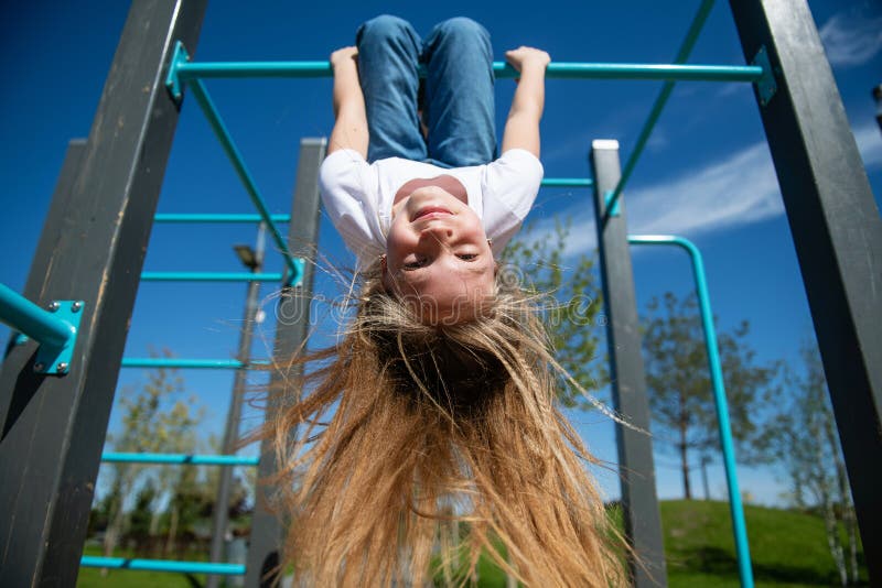 Young girl child playing in garden hanging upside down, MR#543