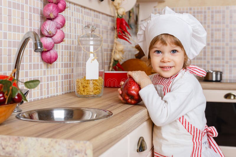 Little Girl In Apron In The Kitchen. Stock Image - Image: 39869495