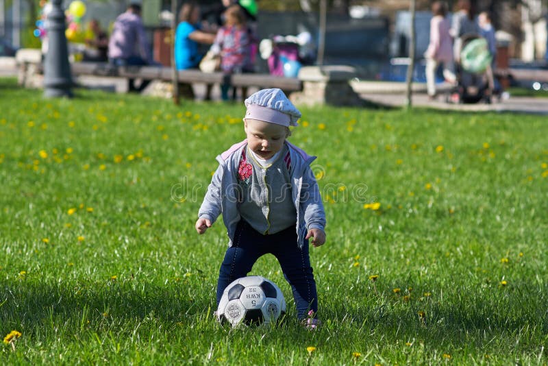 Little girl baby blond Outdoors. Active football