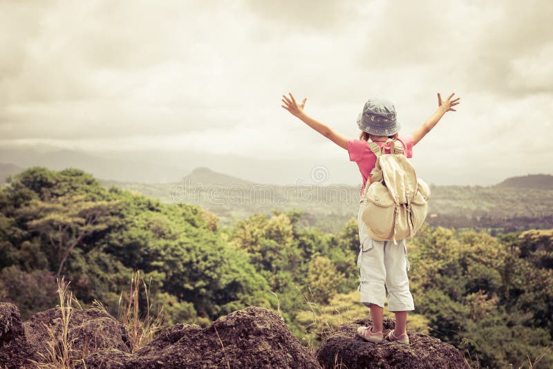 Little girl with a backpack standing on a mountain top royalty free stock image Little girl with a backpack standing on a mountain top royalty free stock image