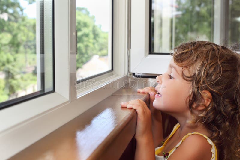 Little girl on balcony, look from window