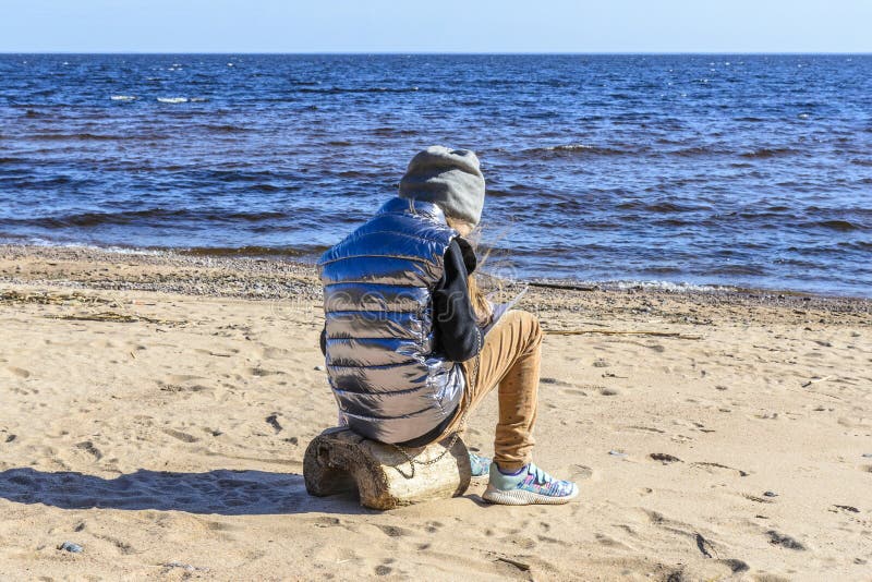 Little Girl on the Beach, Against the Background of Stones, Sand ...