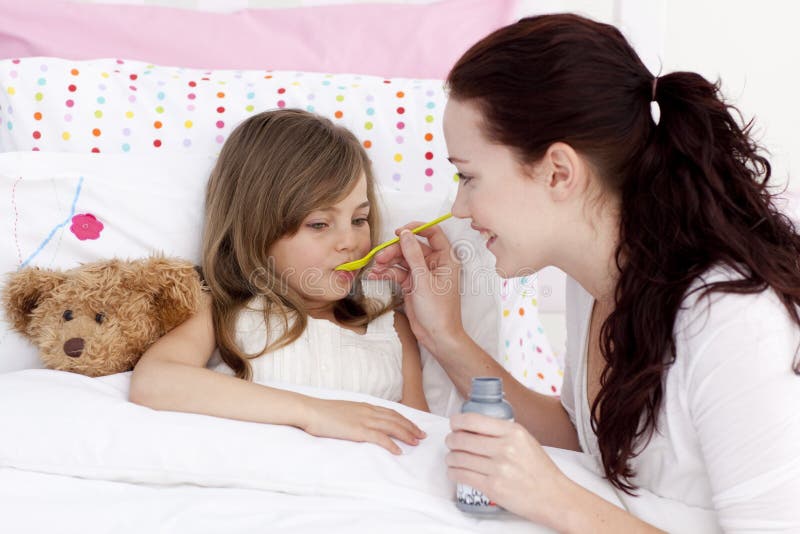 Little girl in bed taking syrup royalty free stock image Little girl in bed taking syrup royalty free stock image