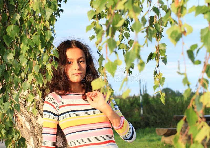 Little girl and birch tree