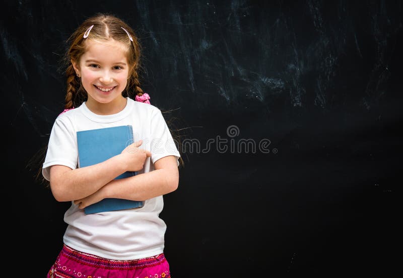 Little girl on black school board background