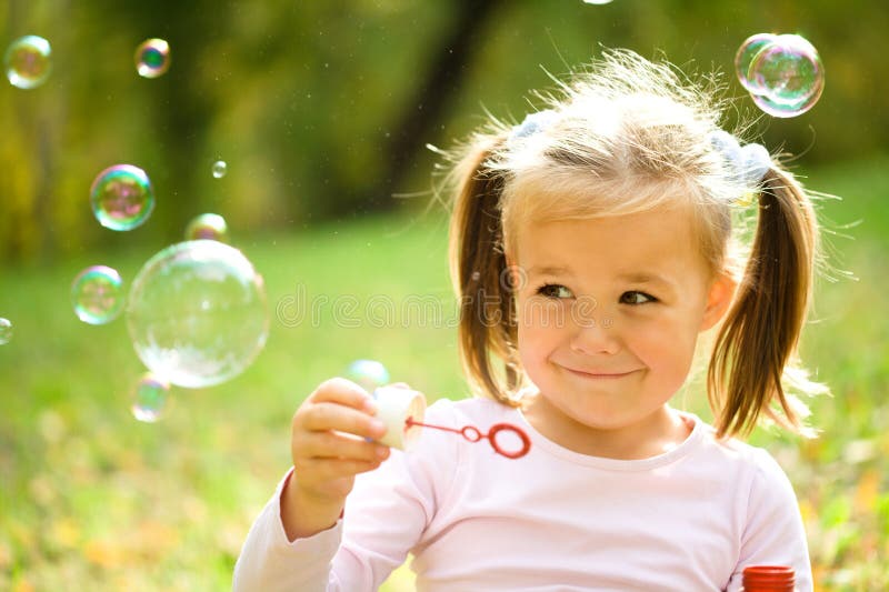 Little girl is blowing a soap bubbles stock image Little girl is blowing a soap bubbles stock image