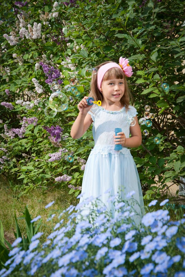Little girl blowing soap bubbles stock photo