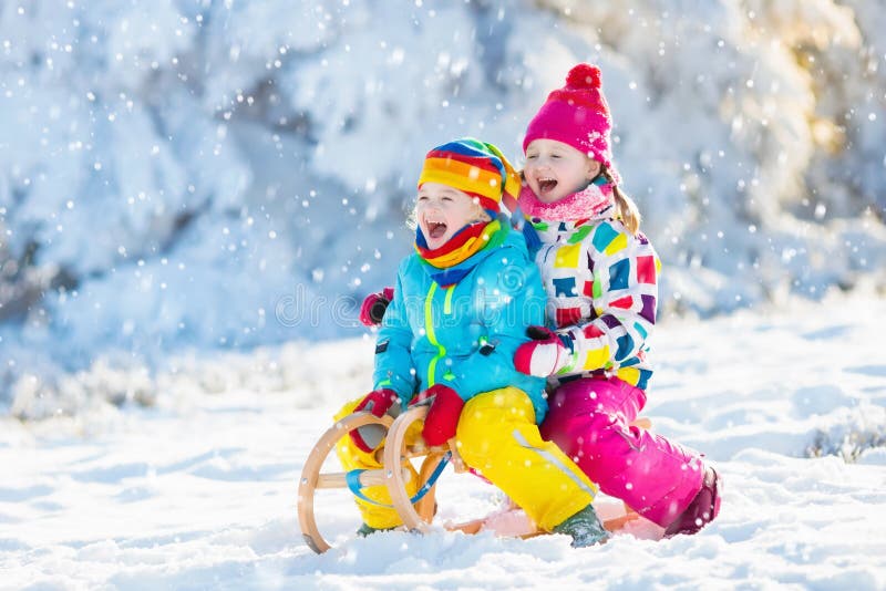 Kids play in snow. Winter sleigh ride for children