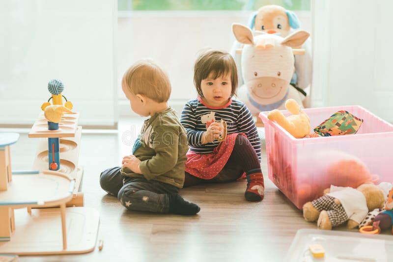 Little girl and boy playing with toys by the home stock images Little girl and boy playing with toys by the home stock images