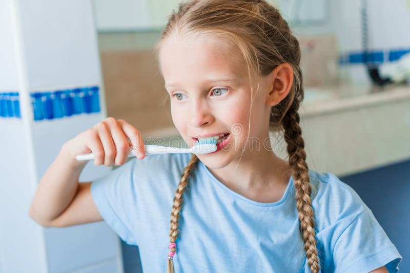 Little Adorable Girl Brushes Teeth in the Bathroom Stock Photo Image