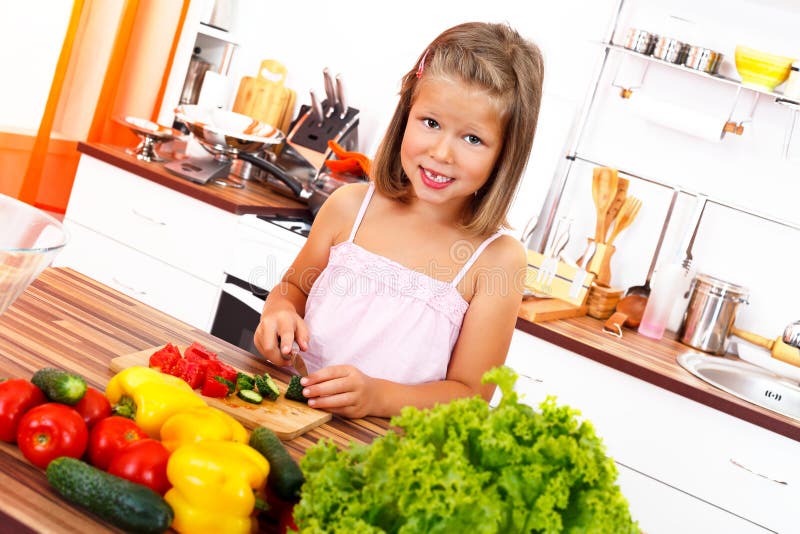 Little girl cutting vegetables