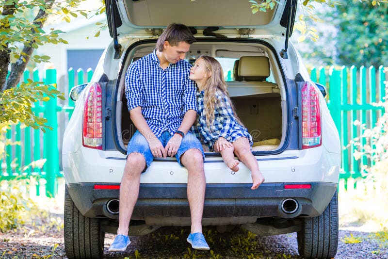 Little girl with dad sitting in a car just before leaving for a car vacation