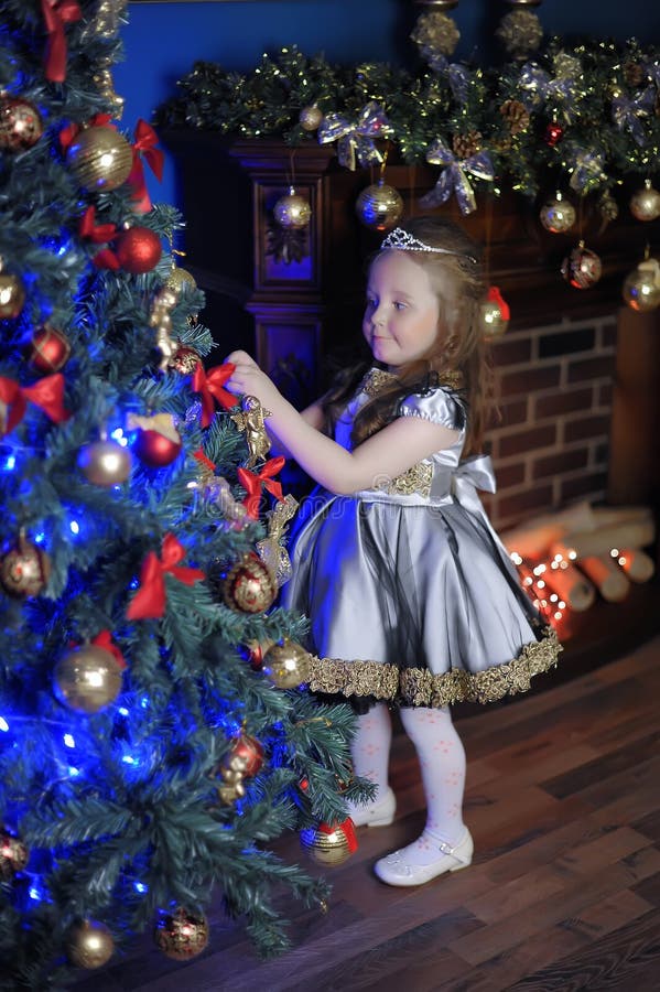 Little girl decorates Christmas tree royalty free stock photo Little girl decorates Christmas tree royalty free stock photo
