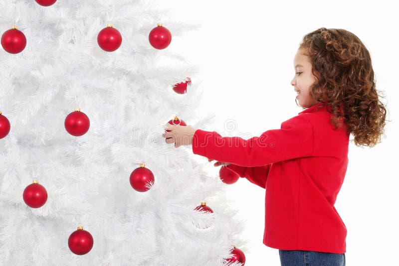 Little girl decorating a christmas tree stock image Little girl decorating a christmas tree stock image