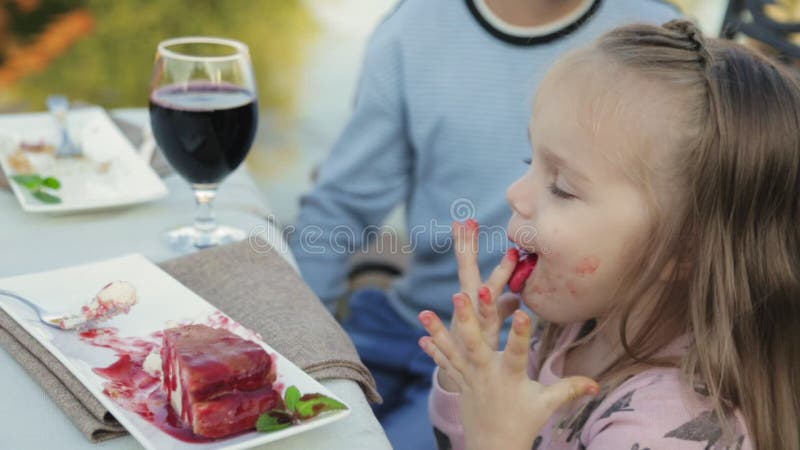 Little girl is dirty after eating dessert in the cafe