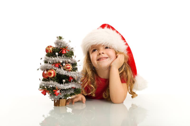 Bambina con il cappello di babbo natale sognando di natale isolato.