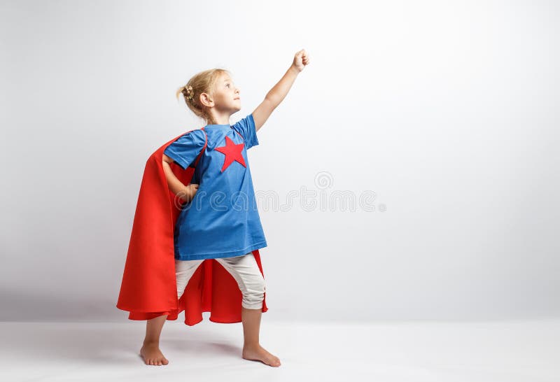 Little girl dressed like superhero standing alongside the white wall. royalty free stock image Little girl dressed like superhero standing alongside the white wall. royalty free stock image