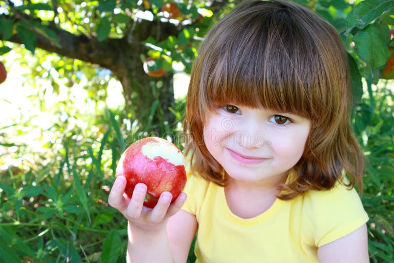 Little girl eating apple stock photo. Image of harvest 16082034
