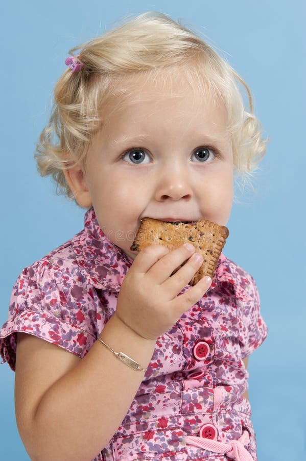 Little Girl Eating a Biscuit. Stock Photo Image of toddler, girls