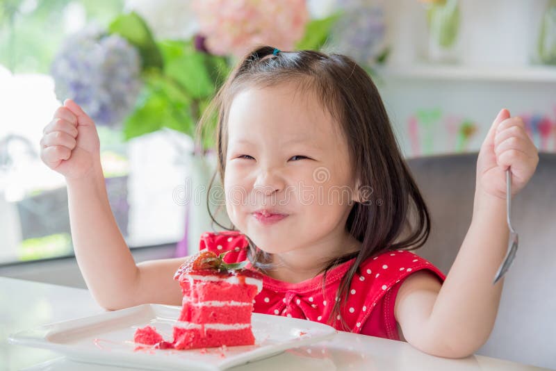 Little girl eating strawberry cake