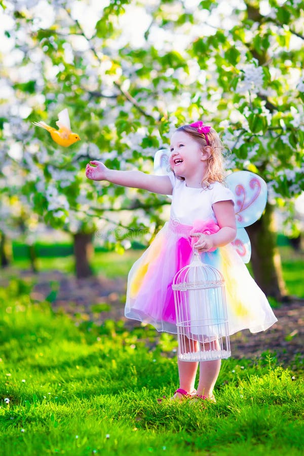 Little girl in fairy costume feeding a bird stock photos Little girl in fairy costume feeding a bird stock photos