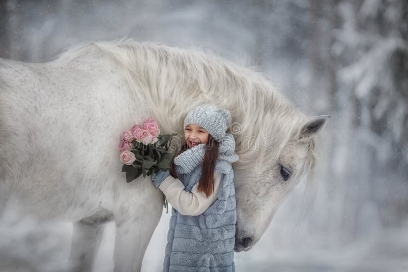 Little girl with with flowers bouquet and white horse