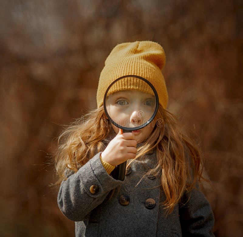 Little girl funny face  portrait with magnifier