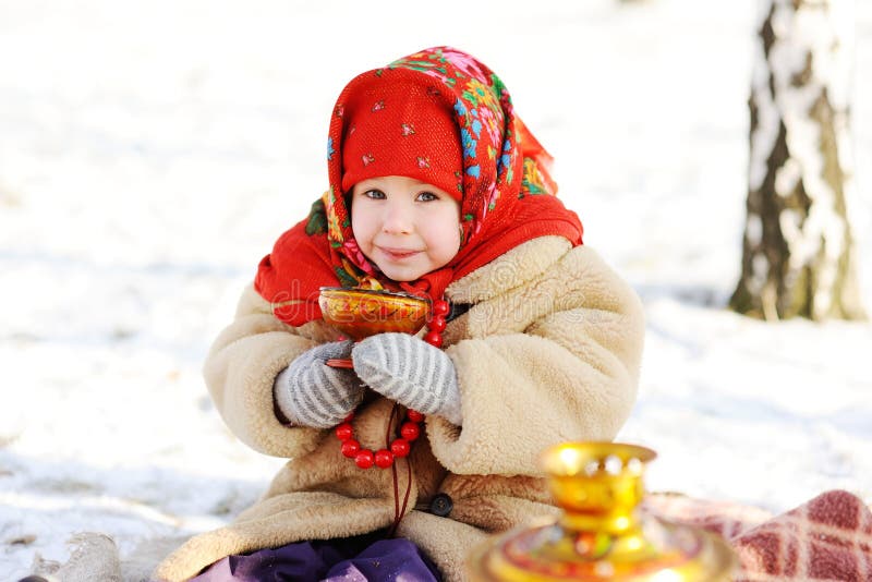 Little girl in a fur coat and red scarf Russian drinking tea on royalty free stock image Little girl in a fur coat and red scarf Russian drinking tea on royalty free stock image