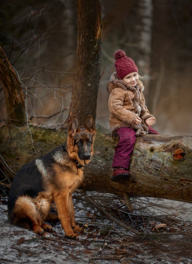 Little girl with German shepherd 6-th months puppy at early spring