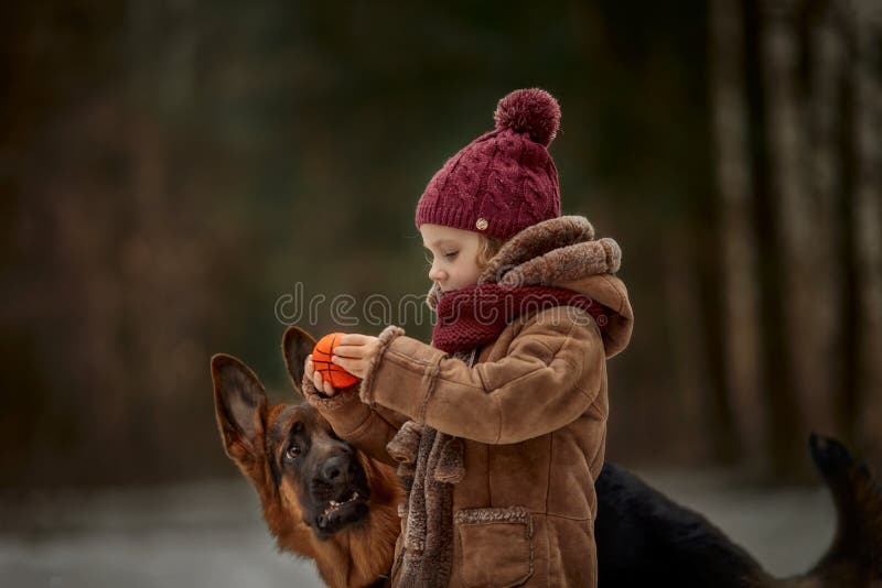 Little girl with German shepherd 6-th months puppy at early spring