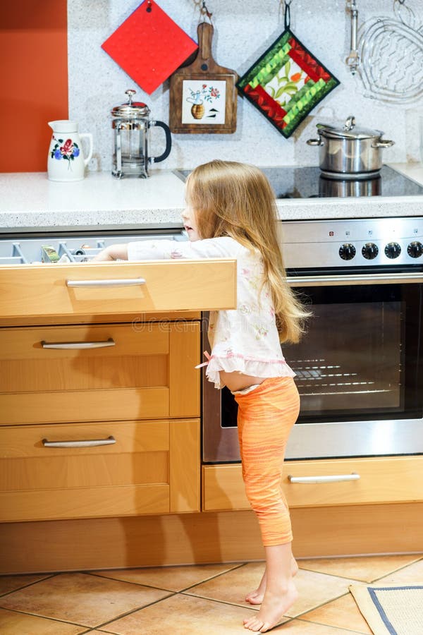 Little girl getting tableware before dinner stock image