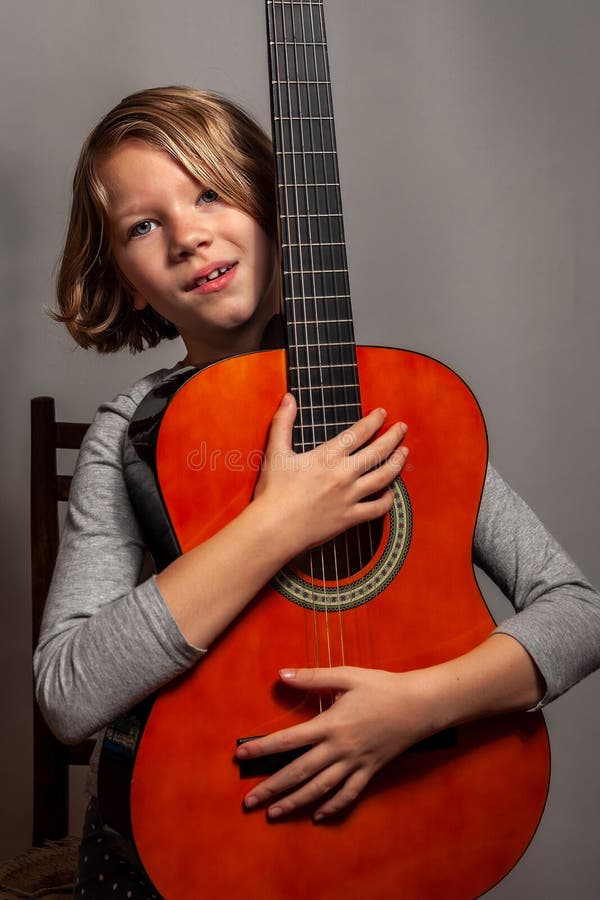 Little girl with guitar on grey background stock photo