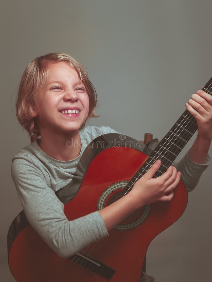 Little girl with guitar on grey background royalty free stock images