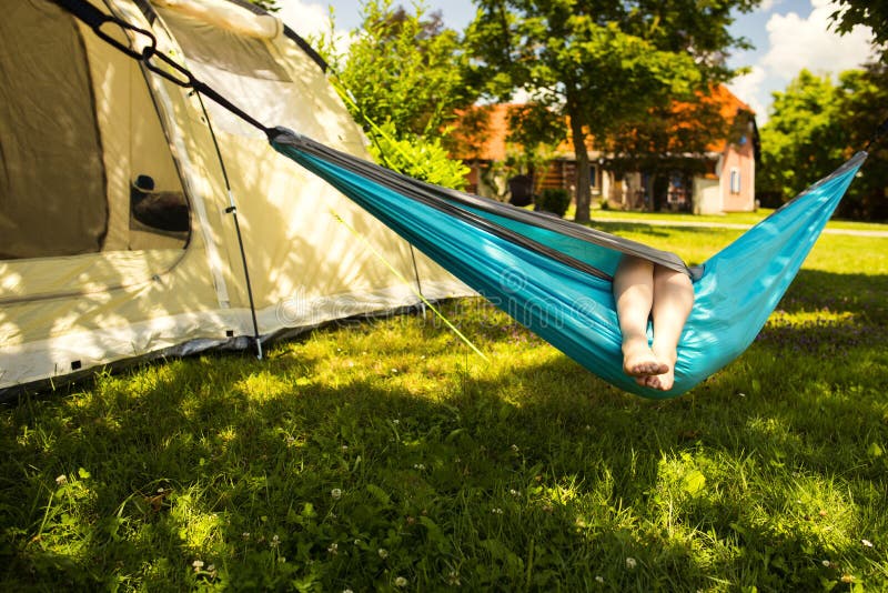 Little girl in the hammock and the tent in background stock images Little girl in the hammock and the tent in background stock images
