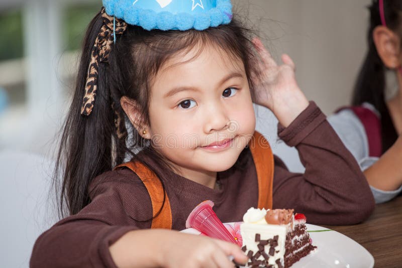 Little girl with hat eating birthday cake royalty free stock photography Little girl with hat eating birthday cake royalty free stock photography