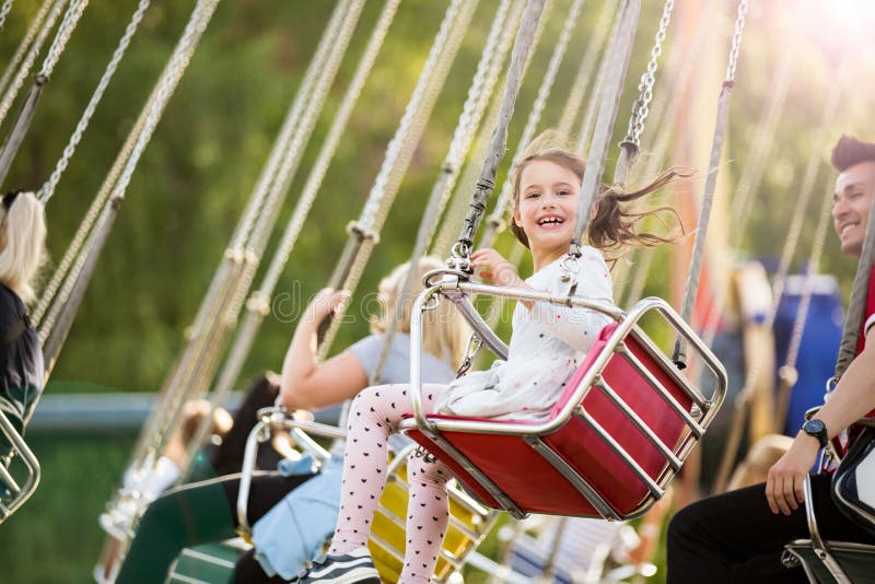 Little girl having fun on chain carousel.