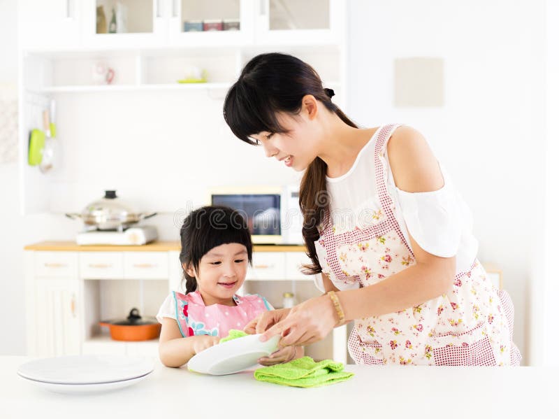 Little girl helping her mother clean dish in the kitchen royalty free stock image Little girl helping her mother clean dish in the kitchen royalty free stock image