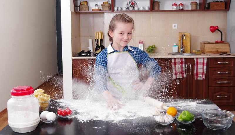 Little girl is helping to bake in a messy kitchen royalty free stock image