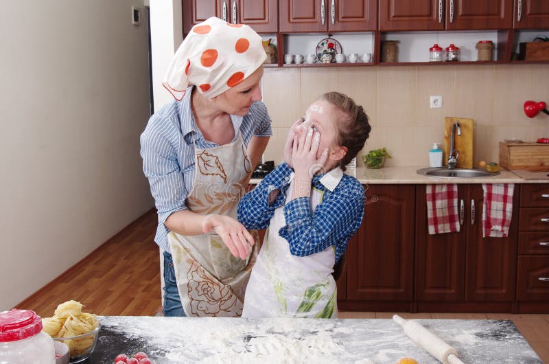 Little girl is helping to bake in a messy kitchen