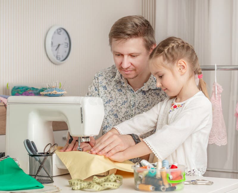 Little girl and her dad in a sewing workshop royalty free stock photography
