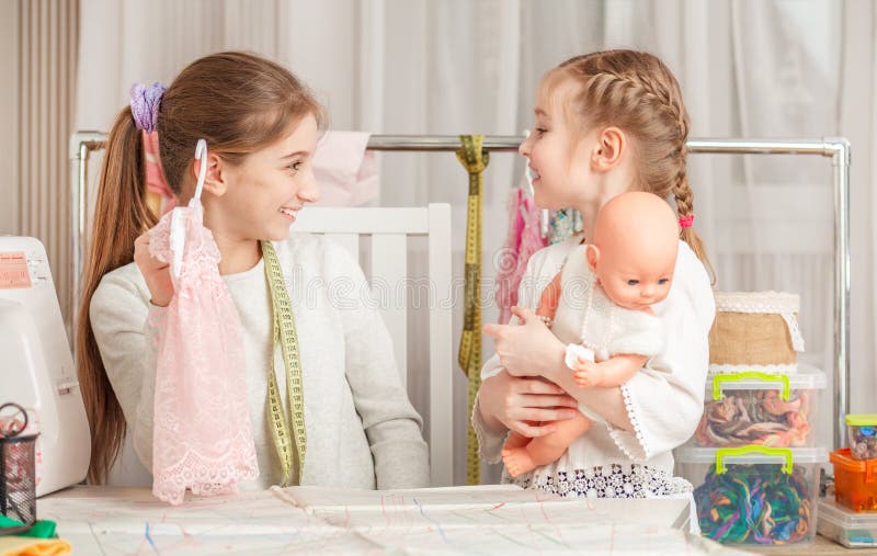 Little girl and her sister in a sewing workshop stock image